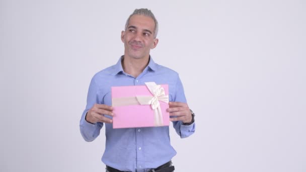 Feliz hombre de negocios persa pensando mientras sostiene caja de regalo — Vídeos de Stock