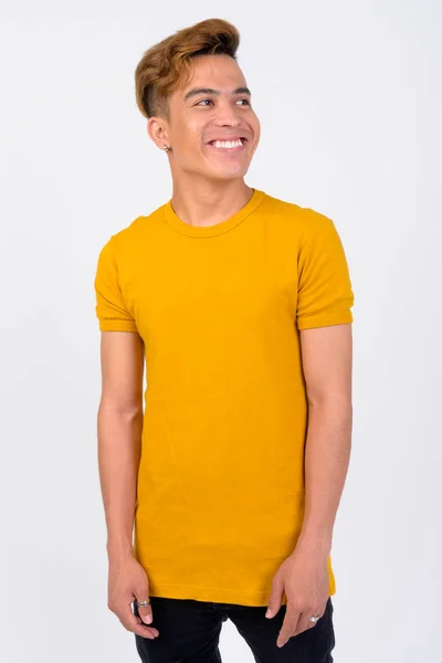 Portrait of happy young Asian man thinking against white background — Stok Foto