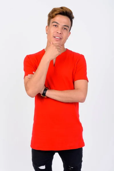 Portrait of young Asian man thinking against white background — Stock Photo, Image