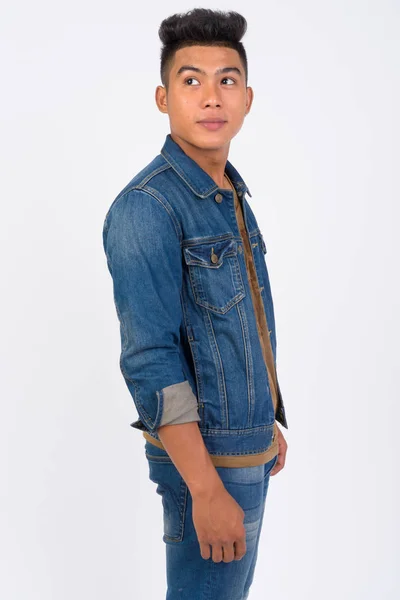 Young Asian man wearing denim jacket thinking and looking up — Stock Photo, Image