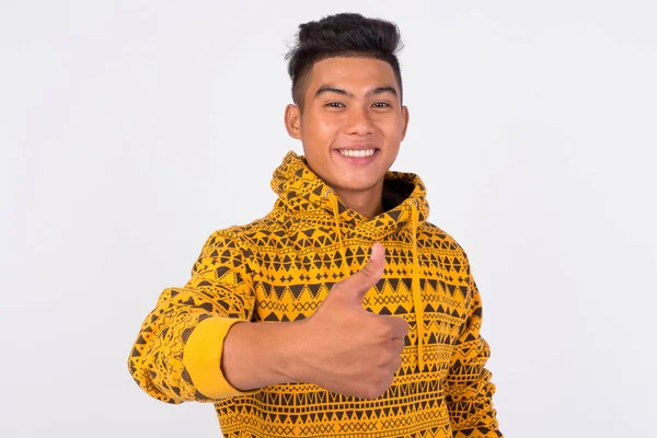 Junge glückliche asiatische Mann mit Kapuzenpullover geben Daumen nach oben — Stockfoto