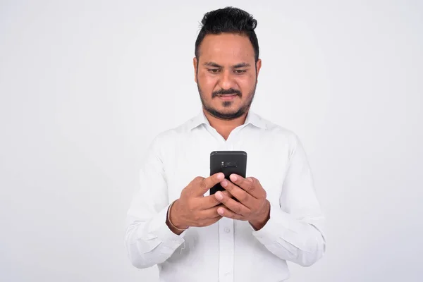 Studio skott av skäggig indisk affärsman med telefon — Stockfoto