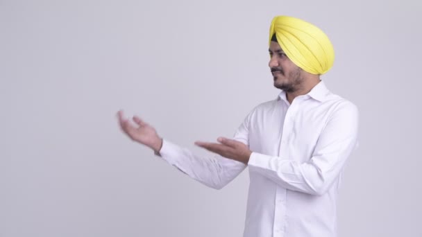 Feliz barbudo indio Sikh empresario mostrando algo — Vídeo de stock