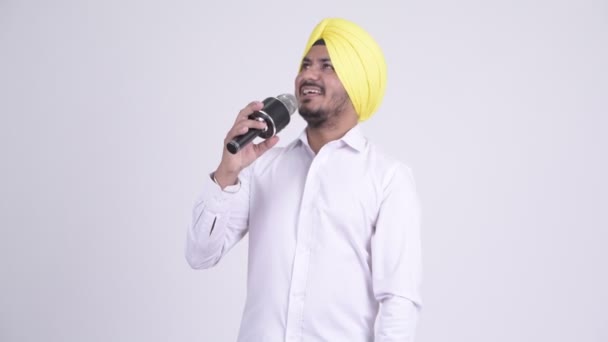 Feliz barbudo indio Sikh hombre de negocios cantando con micrófono — Vídeos de Stock