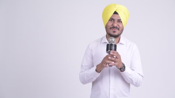 Feliz indiano Sikh empresário apresentando algo com microfone — Vídeo de Stock