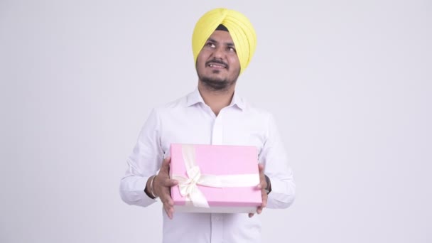 Feliz barbudo indio Sikh empresario pensando mientras sostiene caja de regalo — Vídeo de stock