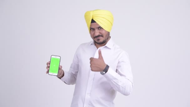 Heureux homme d'affaires indien sikh montrant téléphone et donnant pouces vers le haut — Video