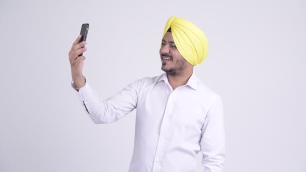 Happy γενειοφόρος Σιχ Ινδός επιχειρηματίας βιντεοκλήσεις με τηλέφωνο — Αρχείο Βίντεο