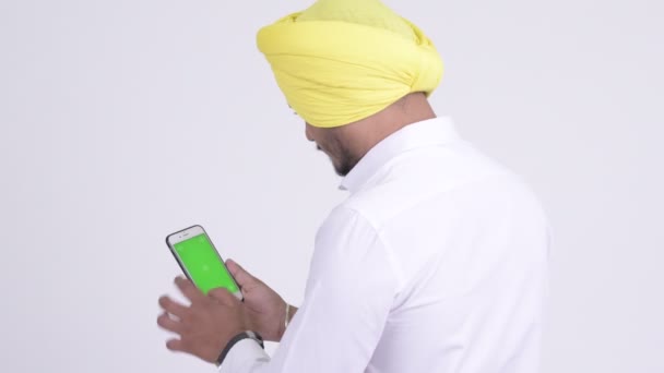 Vista trasera del hombre de negocios Sikh indio barbudo usando el teléfono — Vídeo de stock