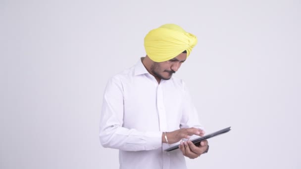 Empresario indio barbudo Sikh estresado usando tableta digital y recibiendo malas noticias — Vídeo de stock