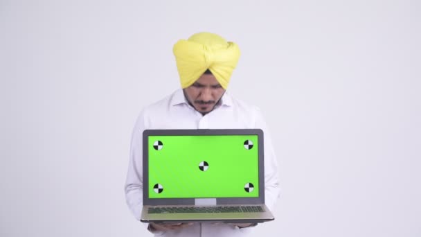 Gelukkig bebaarde Indische Sikh zakenman op zoek verrast terwijl laptop wordt weergegeven — Stockvideo