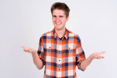 Beyaz arka plan karşı omuz shrugging mutlu yakışıklı delikanlı