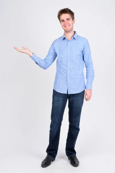 Full body shot de joven empresario feliz mostrando algo — Foto de Stock