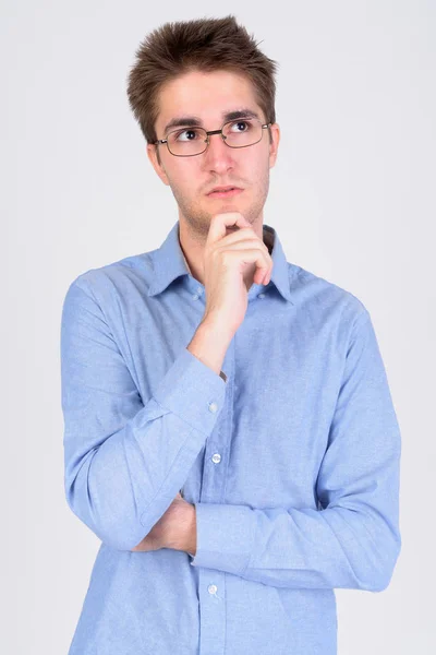 Joven hombre de negocios guapo con anteojos pensando y mirando hacia arriba — Foto de Stock