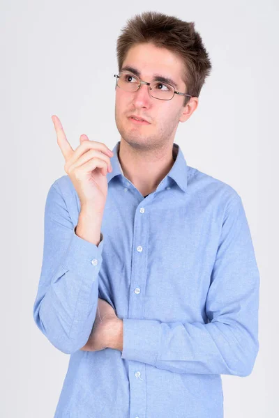 Молодой привлекательный бизнесмен в очках думает и показывает вверх — стоковое фото