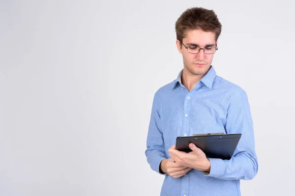 Young handsome businessman with eyeglasses reading on clipboard — Stock Photo, Image