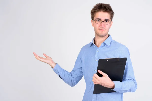 Young handsome businessman holding clipboard and showing something — Stock Photo, Image