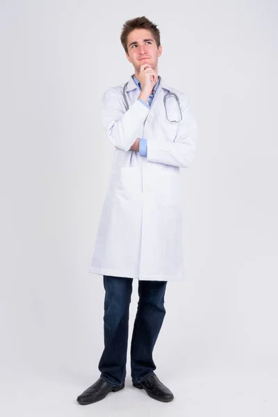 Full body shot of young handsome man doctor thinking — Stock Photo, Image