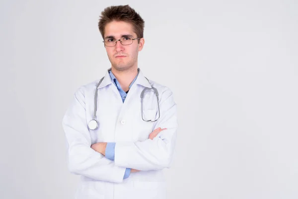 Young handsome man doctor wearing eyeglasses with arms crossed — Stock Photo, Image