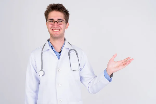 Happy young handsome man doctor with eyeglasses showing something — Stock Photo, Image