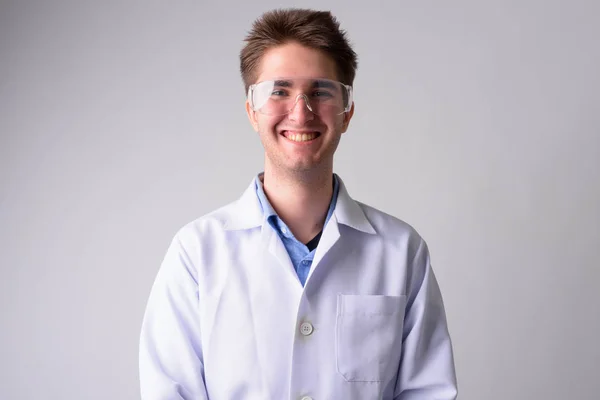 Happy young handsome man doctor with protective glasses — Stock Photo, Image