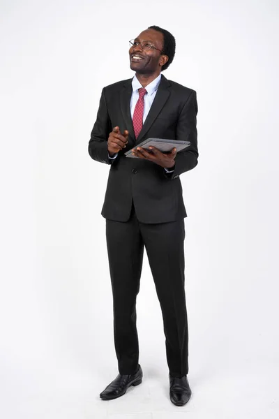 Feliz empresario africano pensando mientras usa la tableta digital —  Fotos de Stock