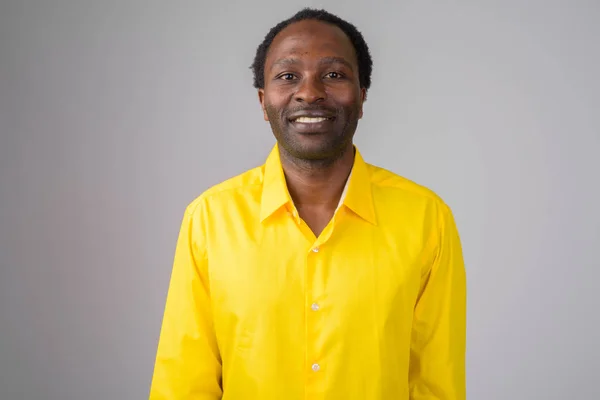 Feliz empresario africano sonriendo mientras usa camisa amarilla —  Fotos de Stock