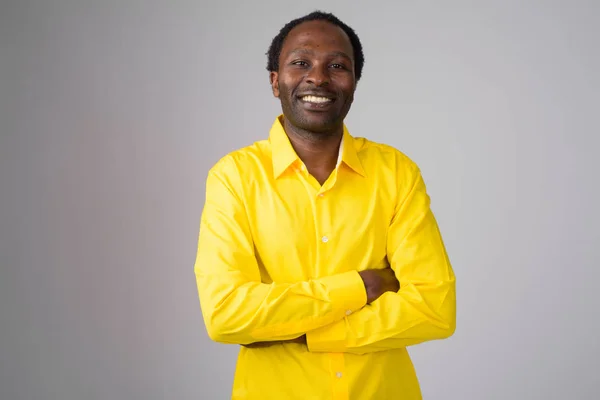 Feliz empresario africano sonriendo con los brazos cruzados —  Fotos de Stock