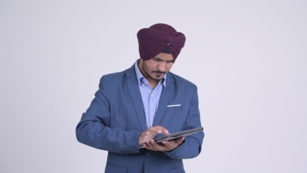 Happy γενειοφόρος Ινδός επιχειρηματίας Σιχ σκέψης ενώ χρησιμοποιώντας ψηφιακή δισκίο — Αρχείο Βίντεο