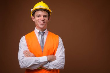 Adam inşaat işçisi kahverengi zemin karşı portresi