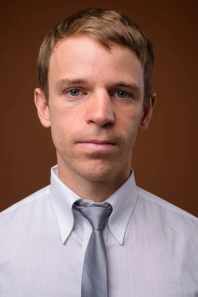 Бизнесмен в белой рубашке на коричневом фоне — стоковое фото