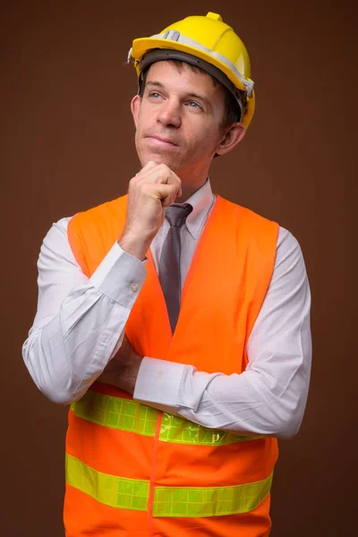 Retrato del trabajador de la construcción del hombre sobre fondo marrón — Foto de Stock