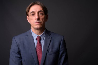 Olgun yakışıklı İtalyan işadamı gri arka plan yüzü