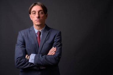 Olgun yakışıklı İtalyan işadamı gri arka planda