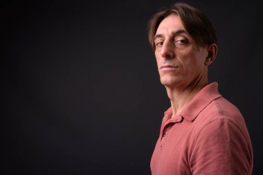 Gri arka planda olgun, yakışıklı bir İtalyan.