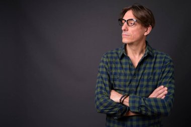 Olgun yakışıklı İtalyan adam gri arka plan üzerinde düşünme