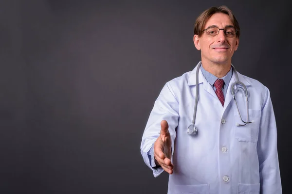 Érett, jóvágású olasz férfi orvos ad kézfogás — Stock Fotó