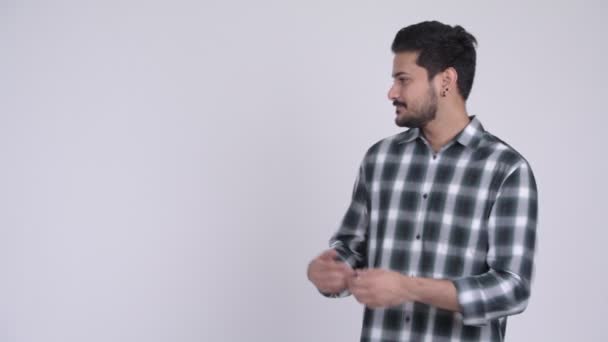 Портрет молодого счастливого бородатого индийца, показывающего что-то — стоковое видео