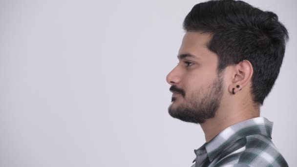 Profile view of young happy bearded Indian man smiling — Stock Video