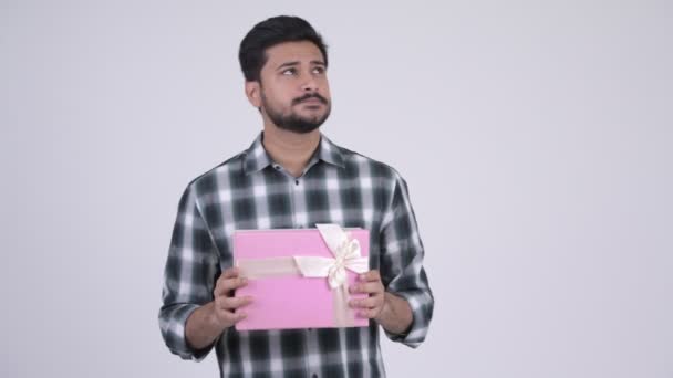 Junge glückliche bärtige indische Mann denken, während sie Geschenk-Box — Stockvideo