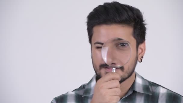 Junge lustige bärtige indische Mann spielt mit Lupe — Stockvideo