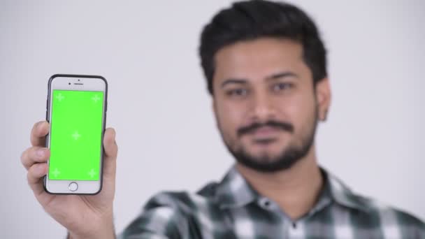 Giovane uomo indiano barbuto felice sorridente mentre mostra il telefono — Video Stock