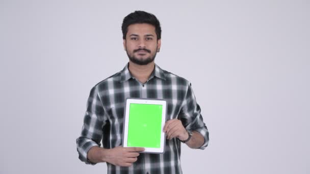 Retrato de joven feliz barbudo hombre indio mostrando tableta digital — Vídeos de Stock