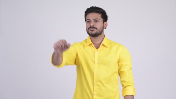 Young happy bearded Indian businessman pointing finger — Stock Video