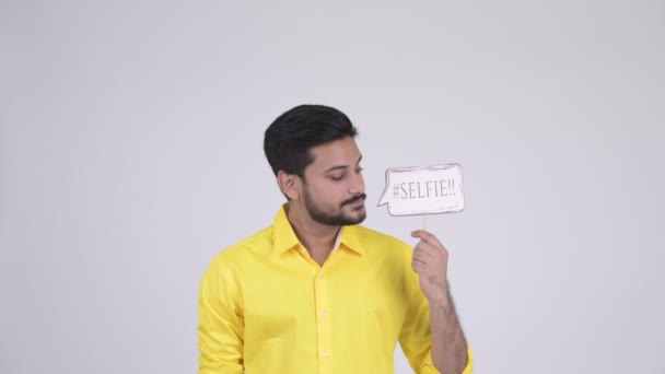 Молодой счастливый бородатый индийский бизнесмен с селфи бумажным знаком — стоковое видео