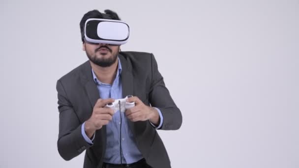 Jovem barbudo indiano empresário jogando jogos e usando fone de ouvido realidade virtual — Vídeo de Stock