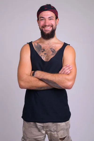 Retrato de joven barbudo feliz hombre rebelde sonriendo con los brazos cruzados — Foto de Stock