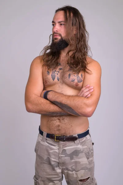 Portrait of bearded young handsome man with long hair thinking shirtless — Stock Fotó