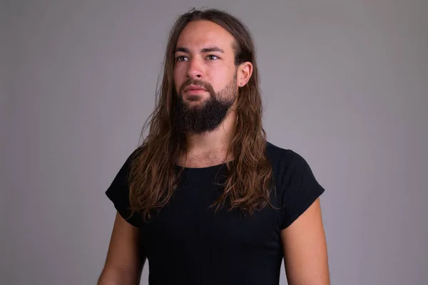 Fiatal jóképű szakállas férfi gondolkodás hosszú haj — Stock Fotó