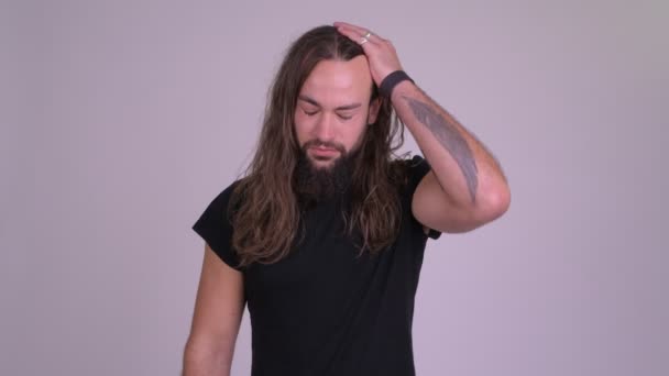 Stressé jeune homme hipster barbu aux cheveux longs donnant pouces vers le bas — Video